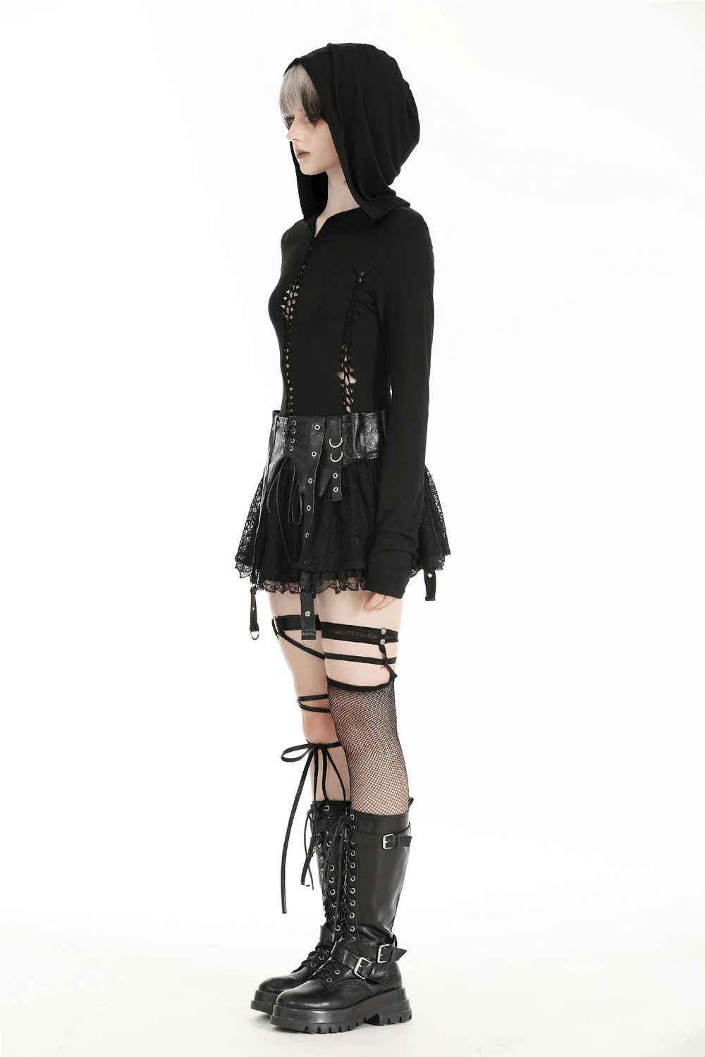 Woman wearing a black gothic hooded cutout long sleeve top with a skirt and combat boots, showcasing edgy alternative fashion.