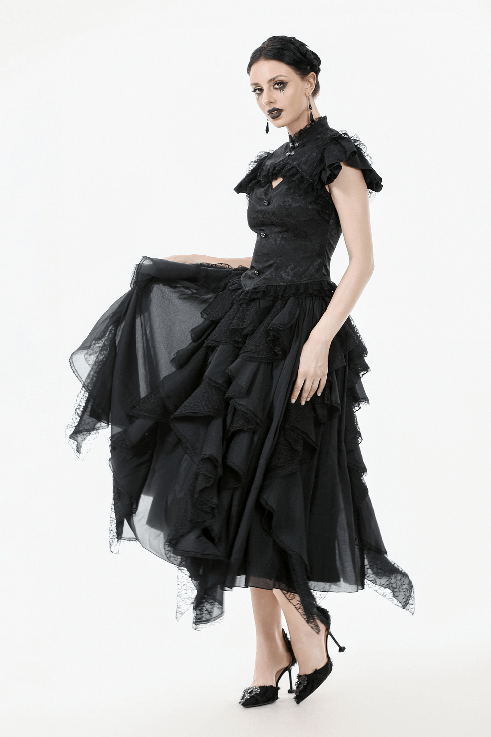 Elegant model in a black gothic jacquard top with puff sleeves and frills, styled in a dramatic layered skirt.