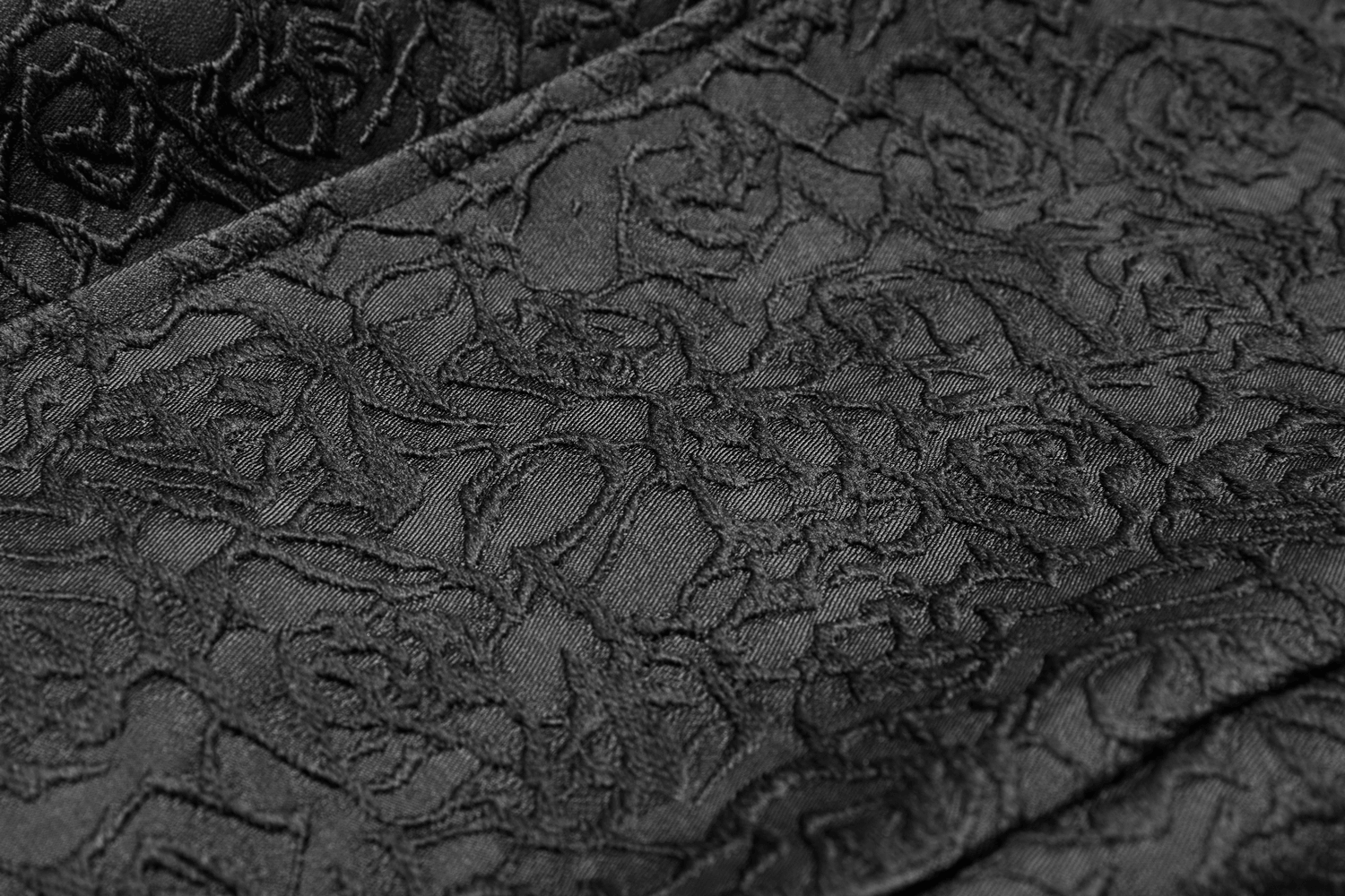 Close-up of intricate black jacquard fabric featuring a floral design, perfect for a gothic waistcoat.