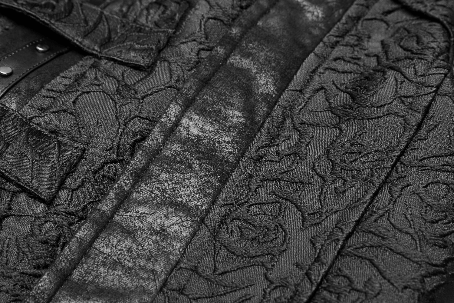 Close-up of black gothic jacquard waistcoat fabric featuring textured floral patterns and buckle accents.