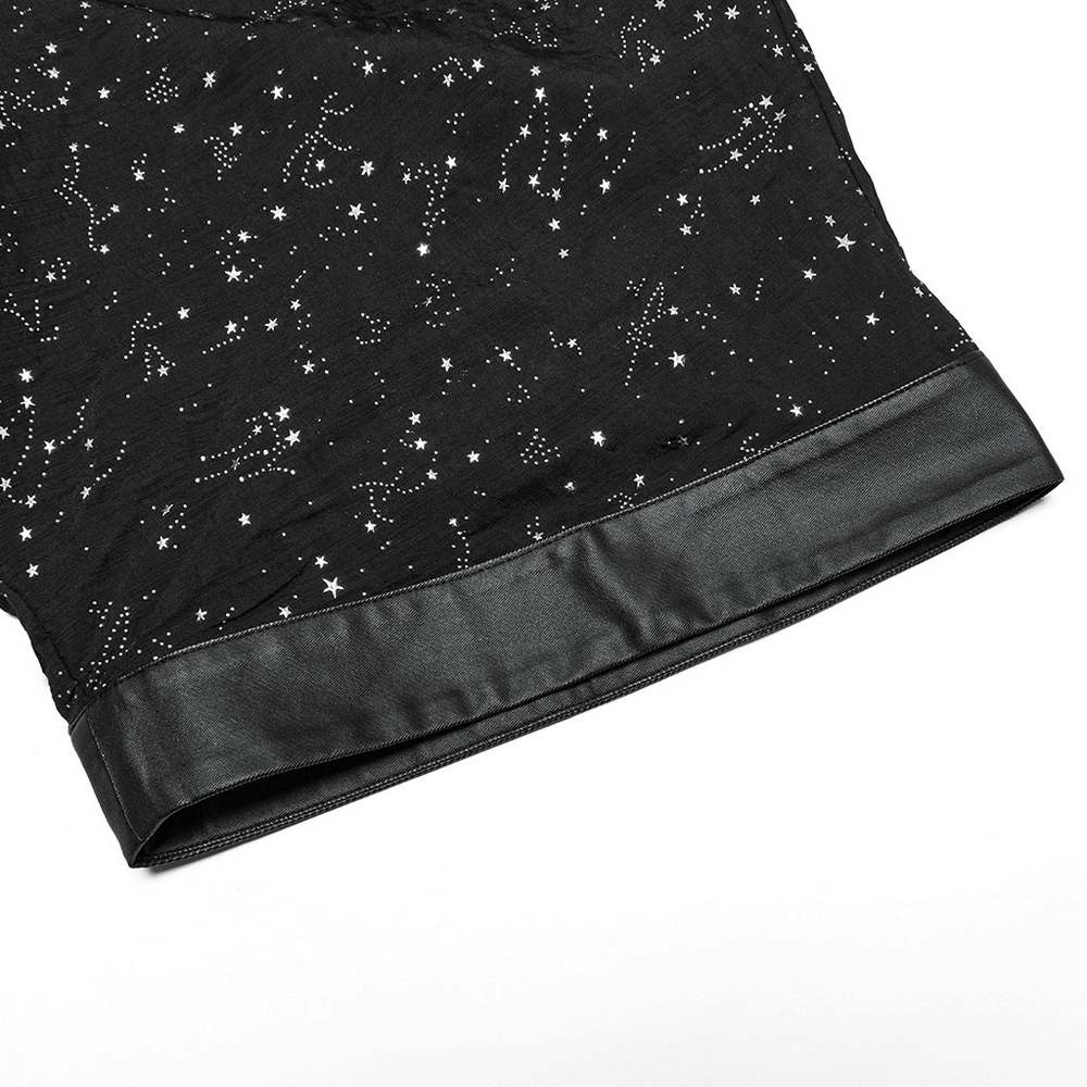 Close-up of the hem of a black gothic kimono cape featuring a starry print and sleek faux leather trim.