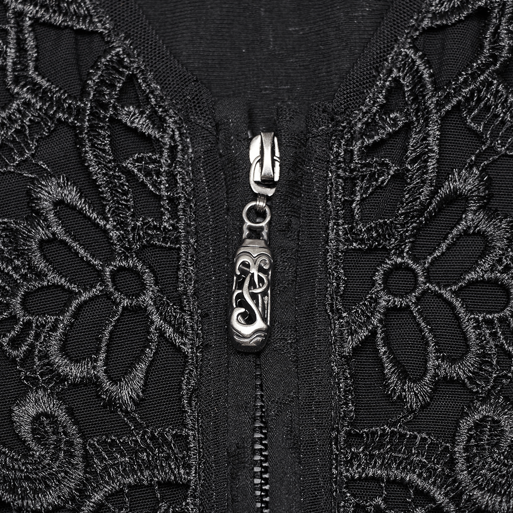 Close-up of gothic lace applique and metal zipper with ornate pendant on black blouse.