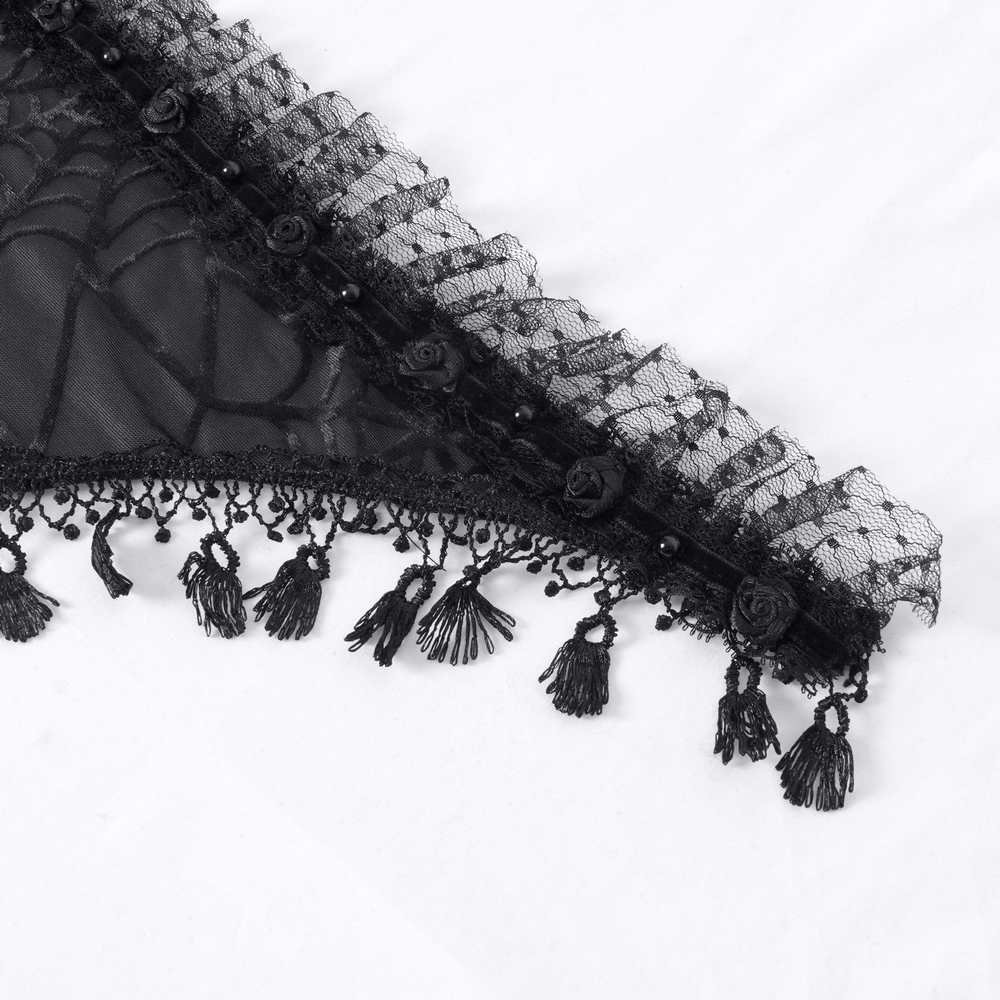 Close-up of a black gothic lace cape edge with spiderweb pattern and decorative tassels.