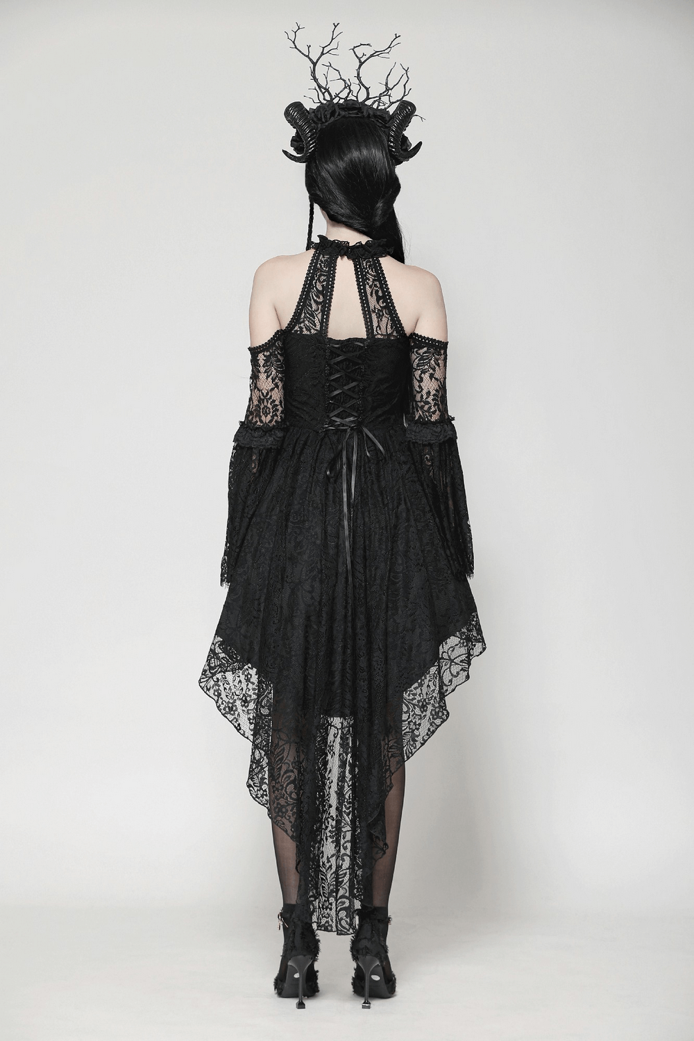Back view of a black gothic lace dress with open shoulders, heart detail, and dramatic high-low hemline.