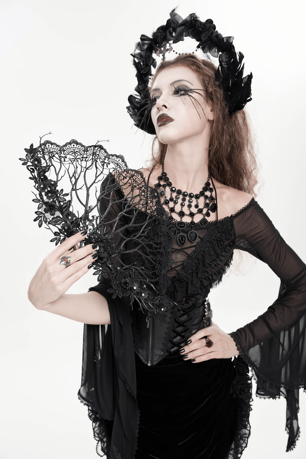 Alt Tag: Model in gothic attire holding Black Gothic Lace Hand Fan with Floral Branch Detail, Victorian dark romance lace accessory for photo shoots