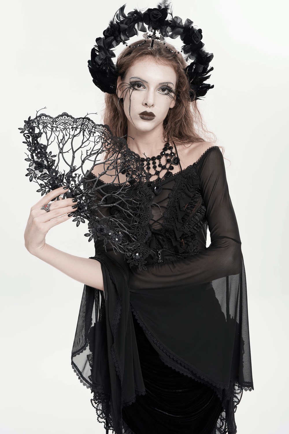 Alt Tag: Black Gothic Lace Hand Fan with Floral Branch Detail held by model in Victorian dark romance gothic look, floral filigree lace openwork