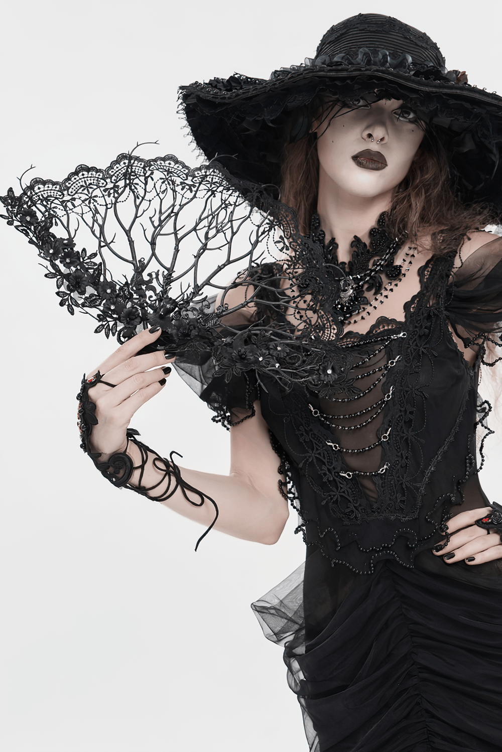 Alt Tag: Black Gothic Lace Hand Fan with Floral Branch Detail held by model in Victorian dark romance outfit, ornate floral filigree lace fan