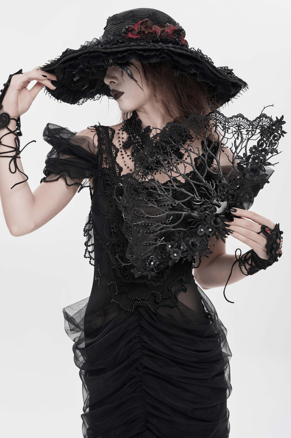 Alt Tag: Black Gothic Lace Hand Fan with Floral Branch Detail held by model in Victorian dark romance outfit, ornate black lace openwork fan