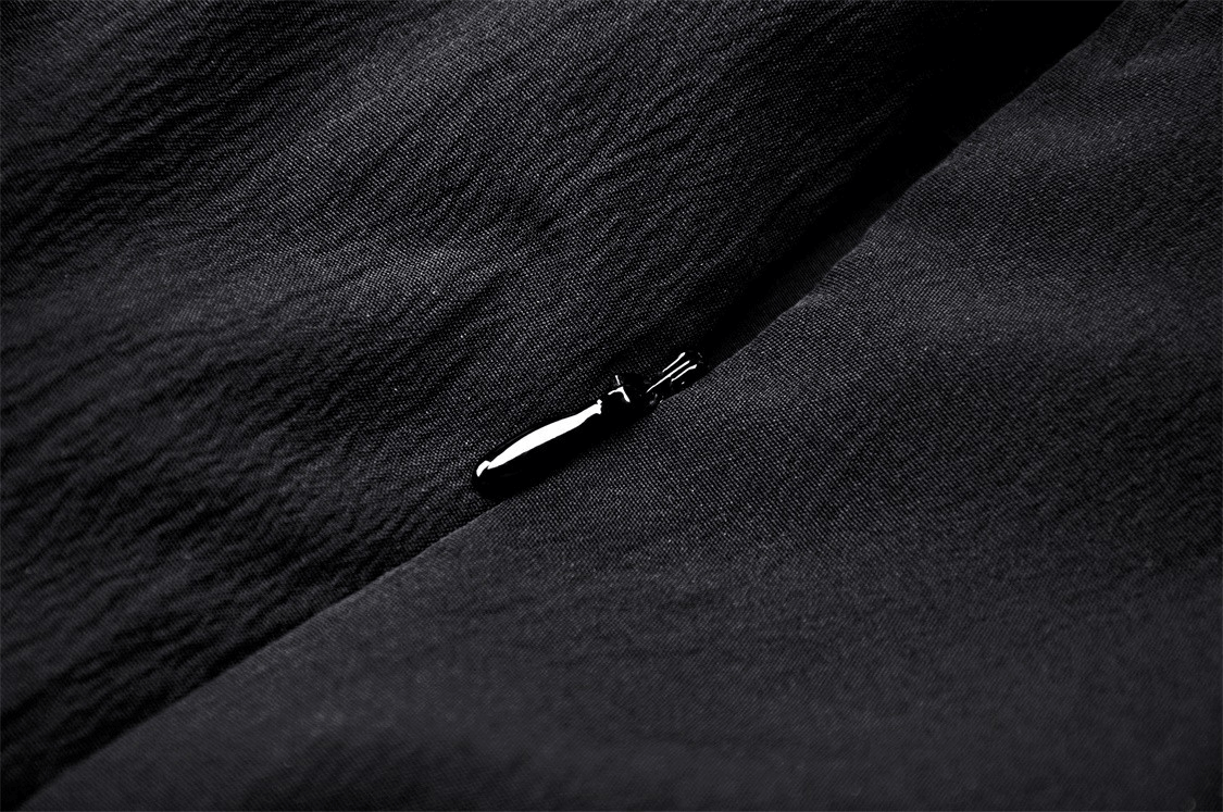 Close-up of black fabric with a delicate lace detailing on a Gothic dress, showcasing rich textures.