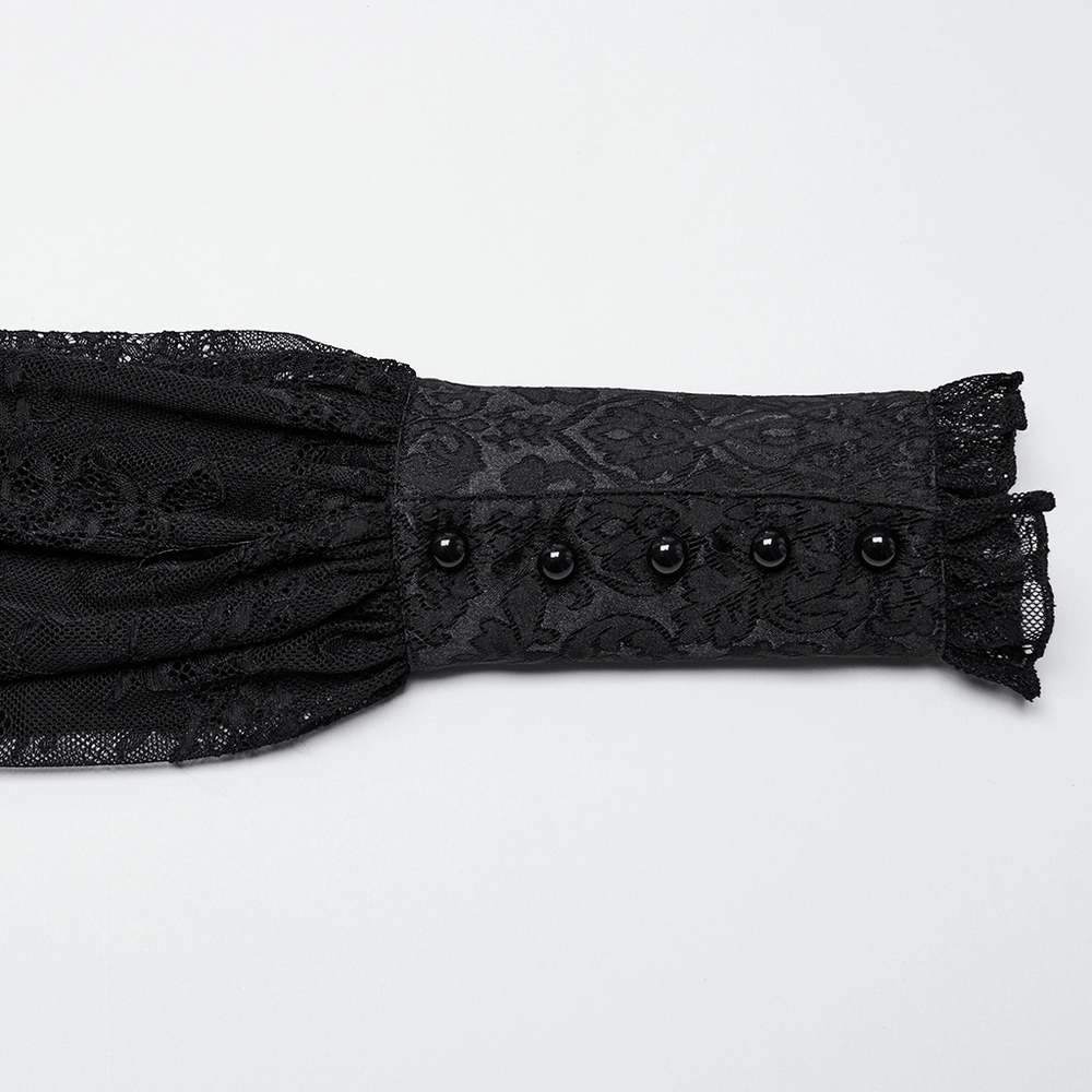 Close-up of a black lace jacquard blouse sleeve with buttons, featuring a gothic corset style.