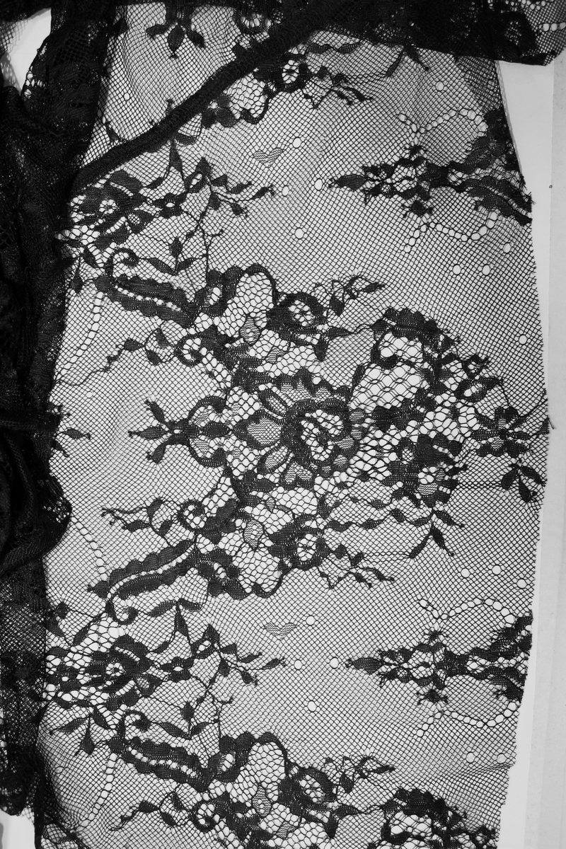 Close-up of intricate black lace pattern featuring floral designs and fine details for a Gothic dress.