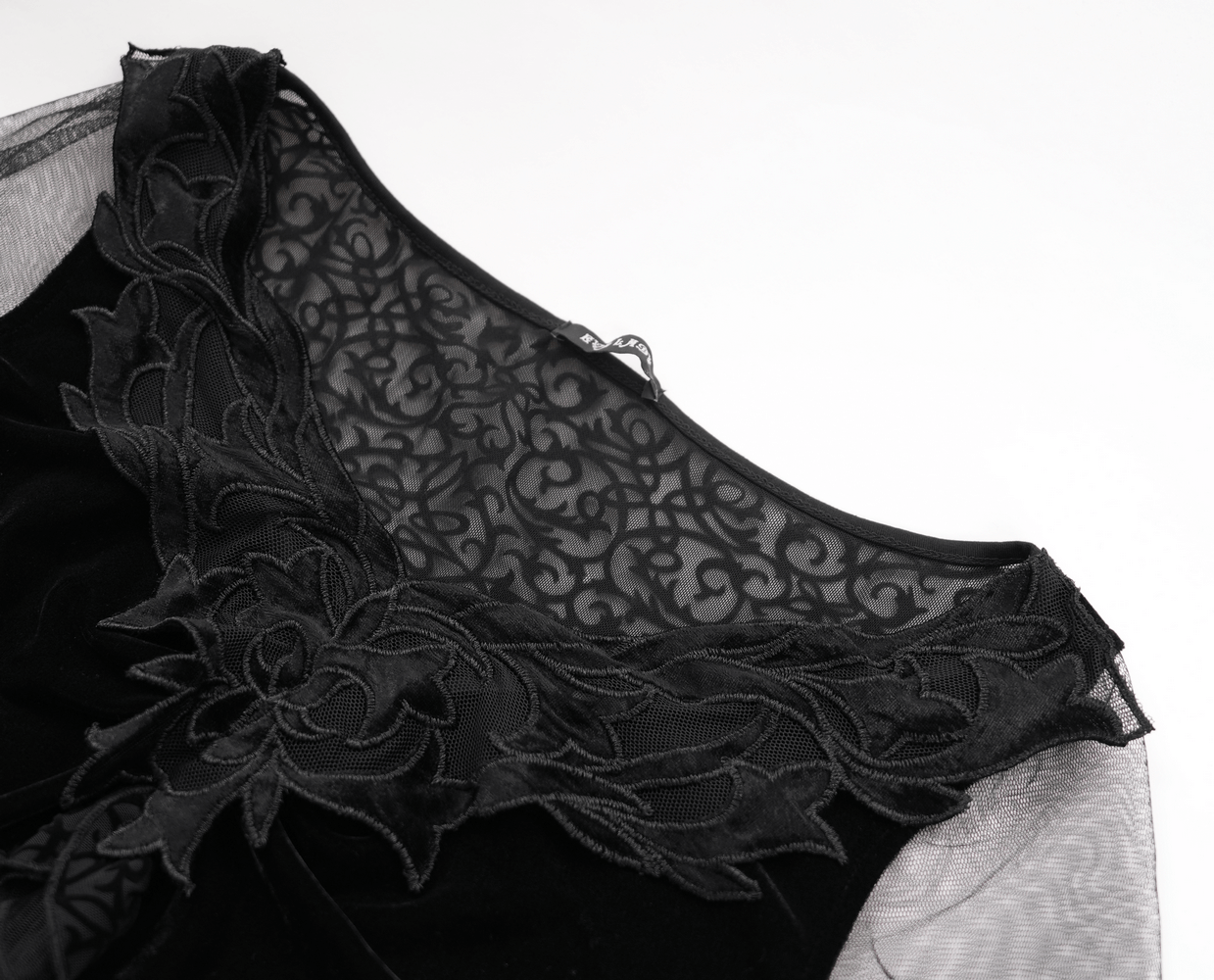 Close-up of black gothic lace top with floral appliqué and mesh detailing on the neckline.