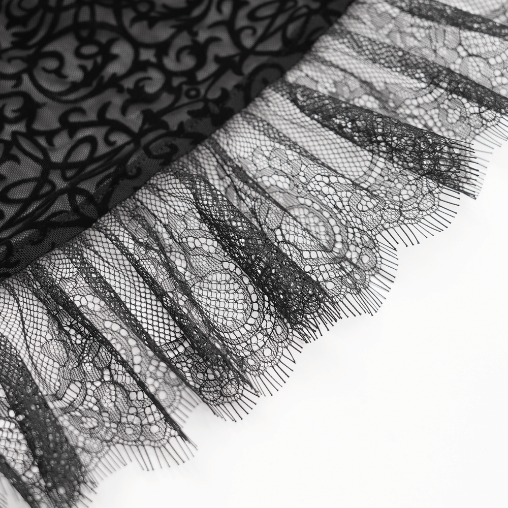 Close-up of delicate black lace trim with intricate patterns and fringed edges, perfect for gothic fashion and elegant layering.