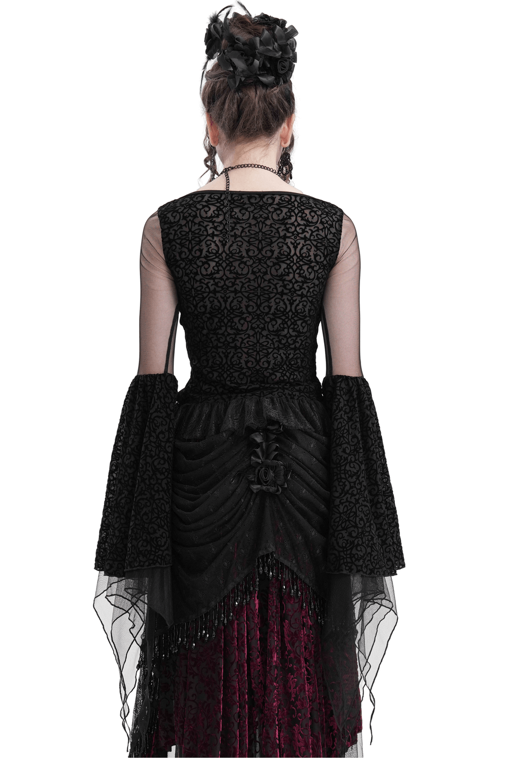 Back view of a black gothic lace top with mesh sleeves and floral details, showcasing flowing bell sleeves and an asymmetrical hem.