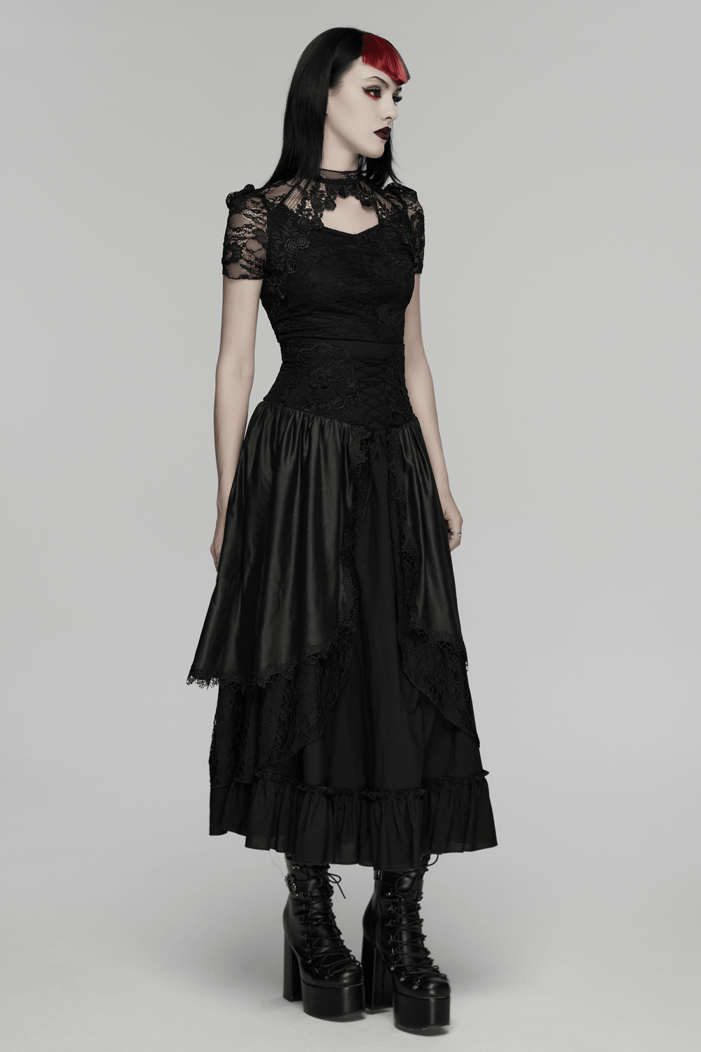 Black Gothic Lace Top with Puff Sleeves Detail worn with layered black skirt and chunky boots, posing elegantly.