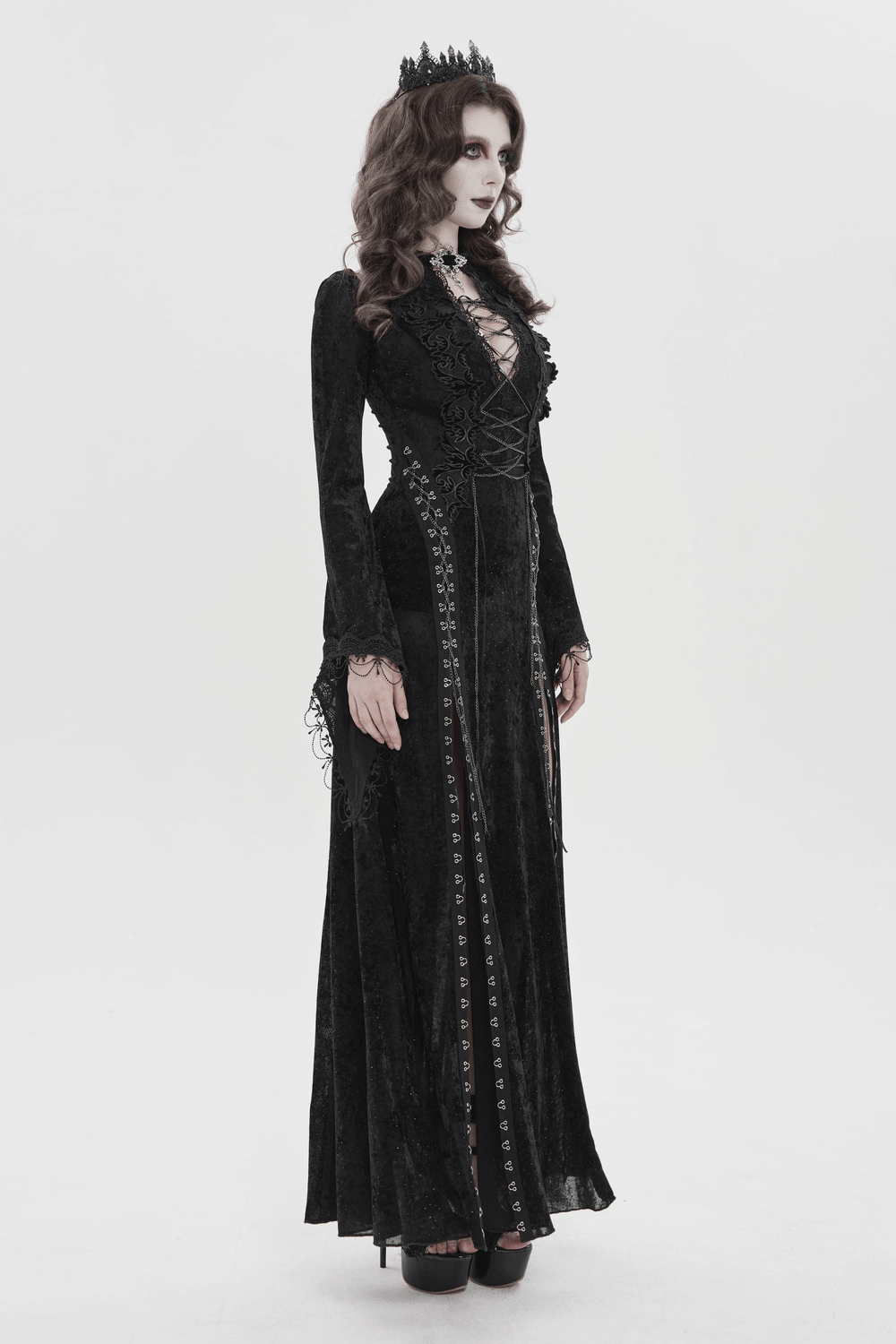 Black Gothic Lace Up Maxi Dress with Bell Sleeves displayed by model in a dramatic pose against a minimalist background.