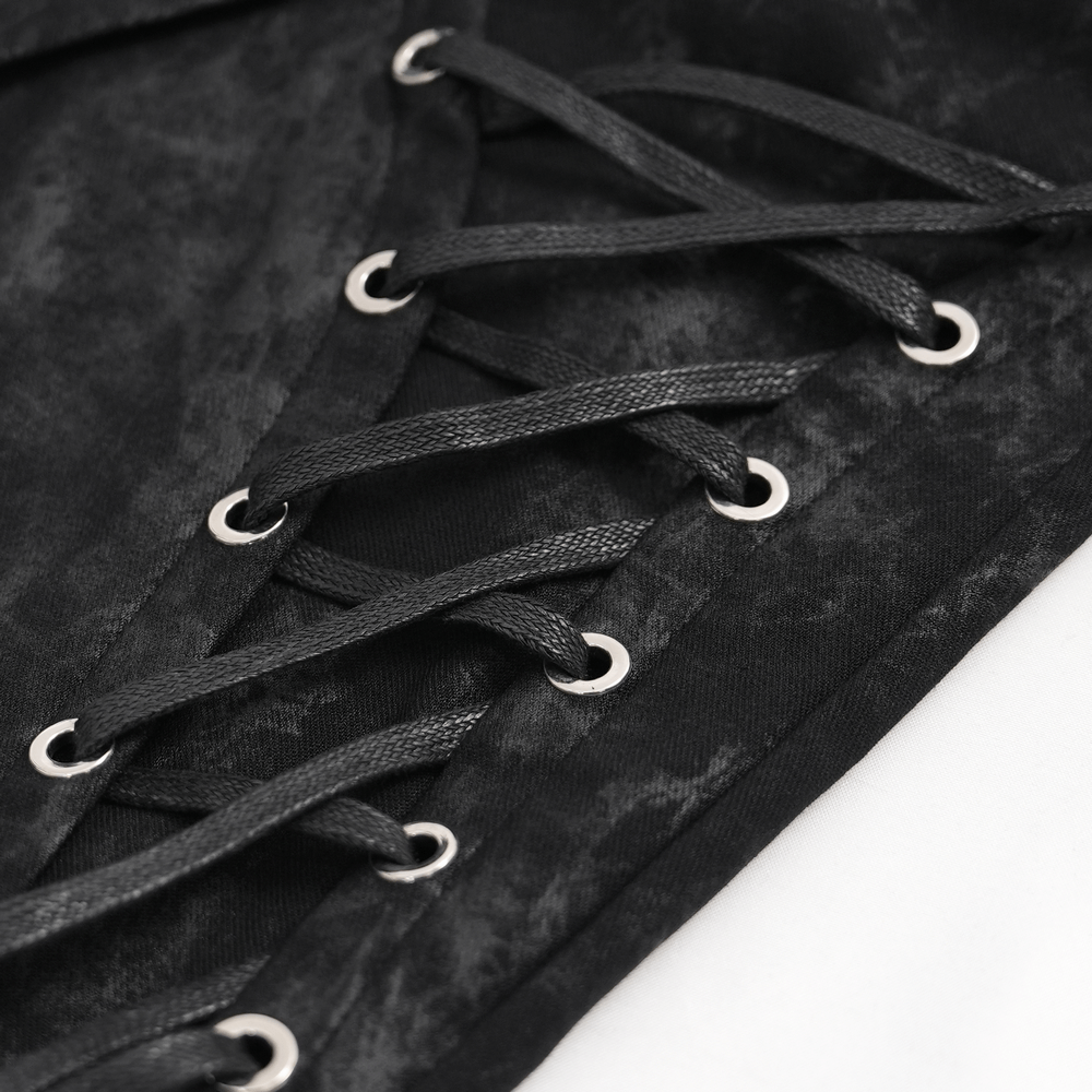 Close-up of black lace-up detailing on gothic pants, showcasing silver eyelets and textured fabric for edgy style.