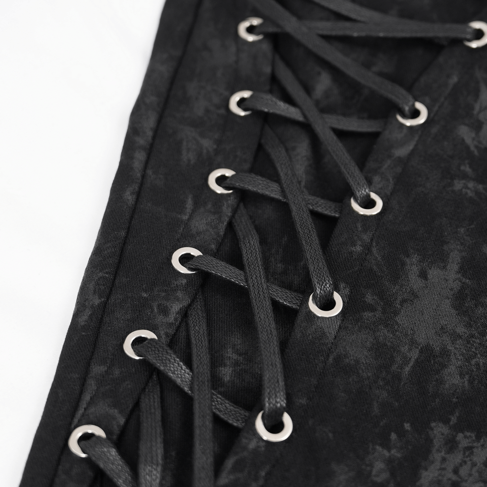 close-up of black gothic lace-up design with silver grommets for edgy ripped skinny pants