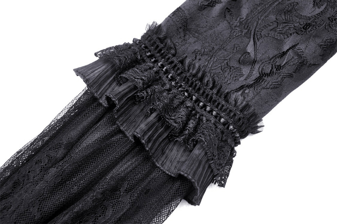Close-up of intricate black lace detailing on gothic maxi dress showcasing elegant ruffles and texture.