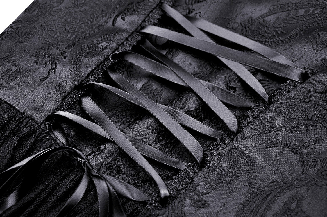 Close-up of intricate black lace fabric with satin ribbons in a corset-style detail, perfect for gothic fashion.