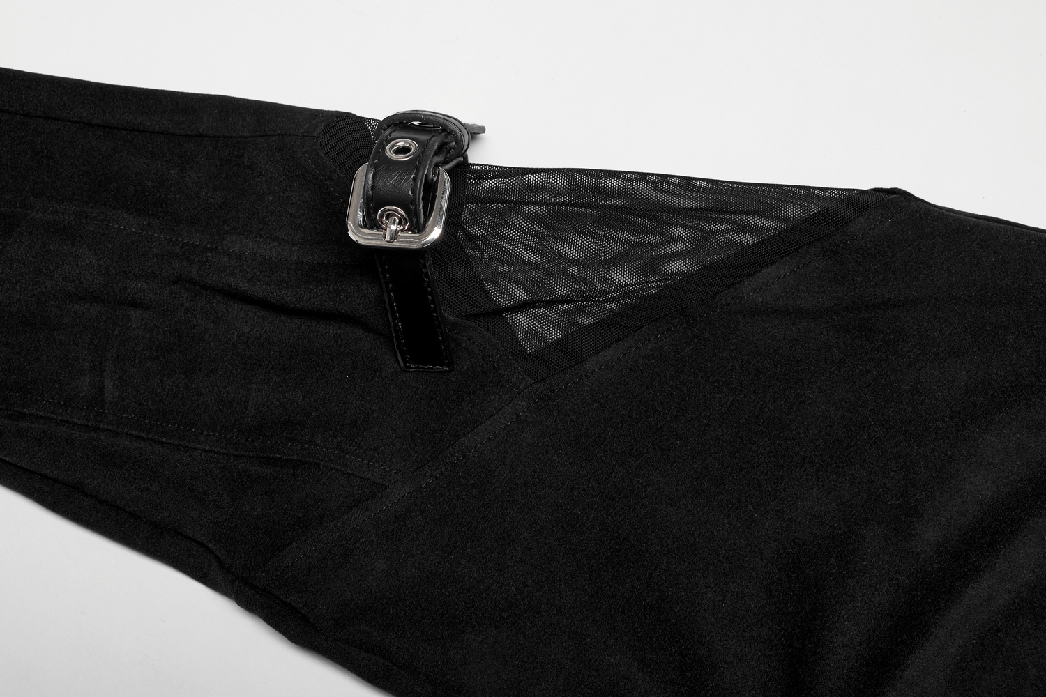 Close-up of black gothic mesh-panel leggings showcasing buckle accents and spliced velvet detail.
