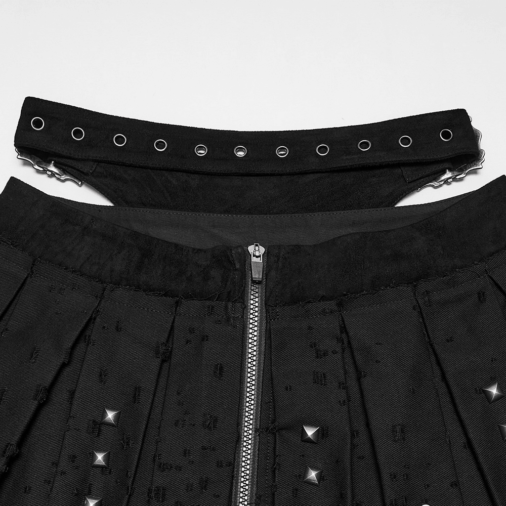 Black Gothic Mini Skirt with Metal Rivet Panels showing pleated fabric and cross buckle accents.