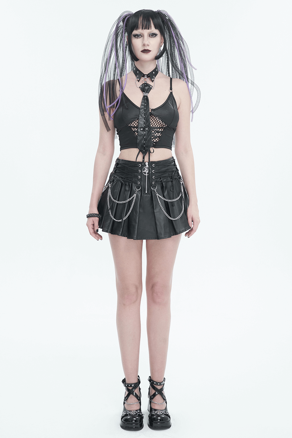 Gothic fashion model in black o-ring studs buckle tie, stylish crop top, and pleated skirt with edgy accessories.
