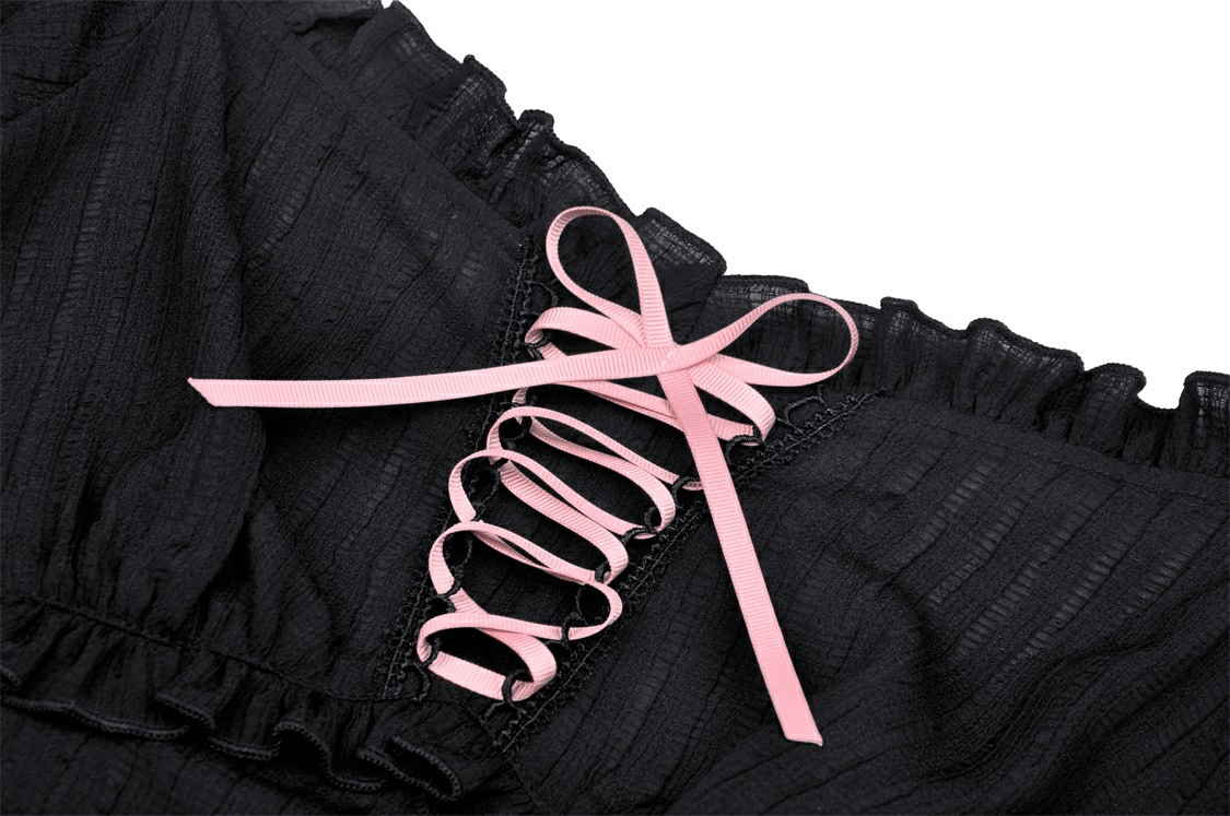 Close-up of black Gothic top with pink ribbon detailing and ruffled neckline, perfect for a dark romantic look.