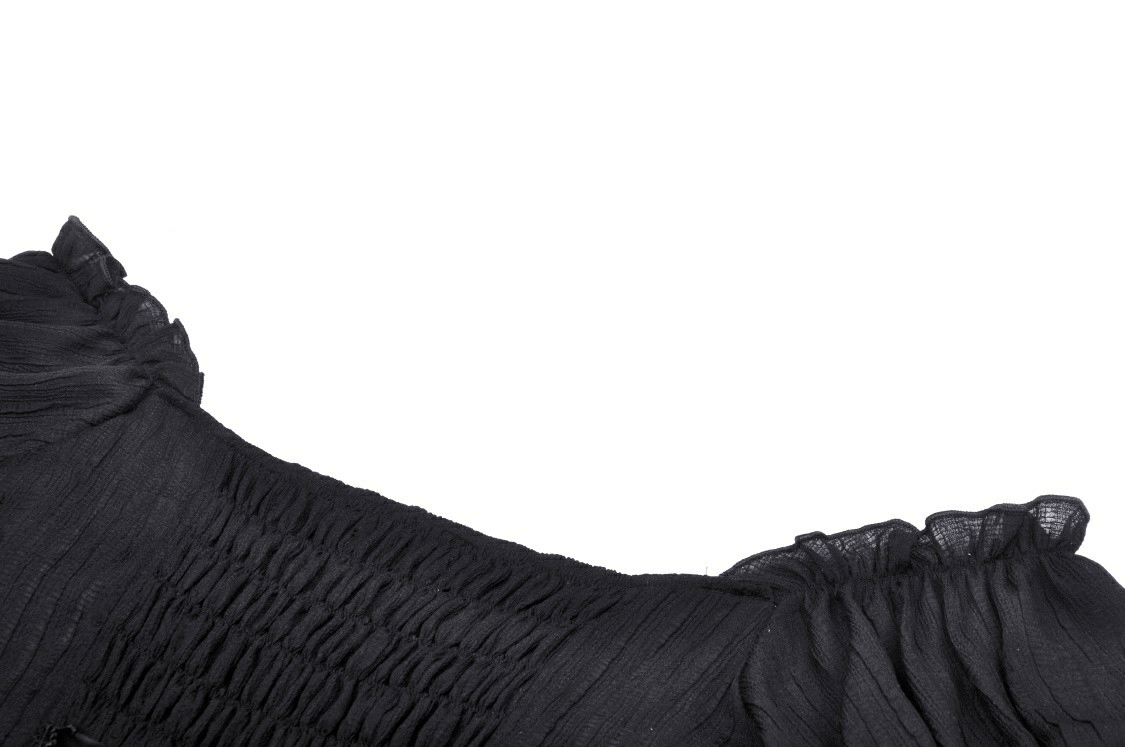 Close-up of black gothic off-the-shoulder top showcasing ruffled neckline and smocked fabric details.