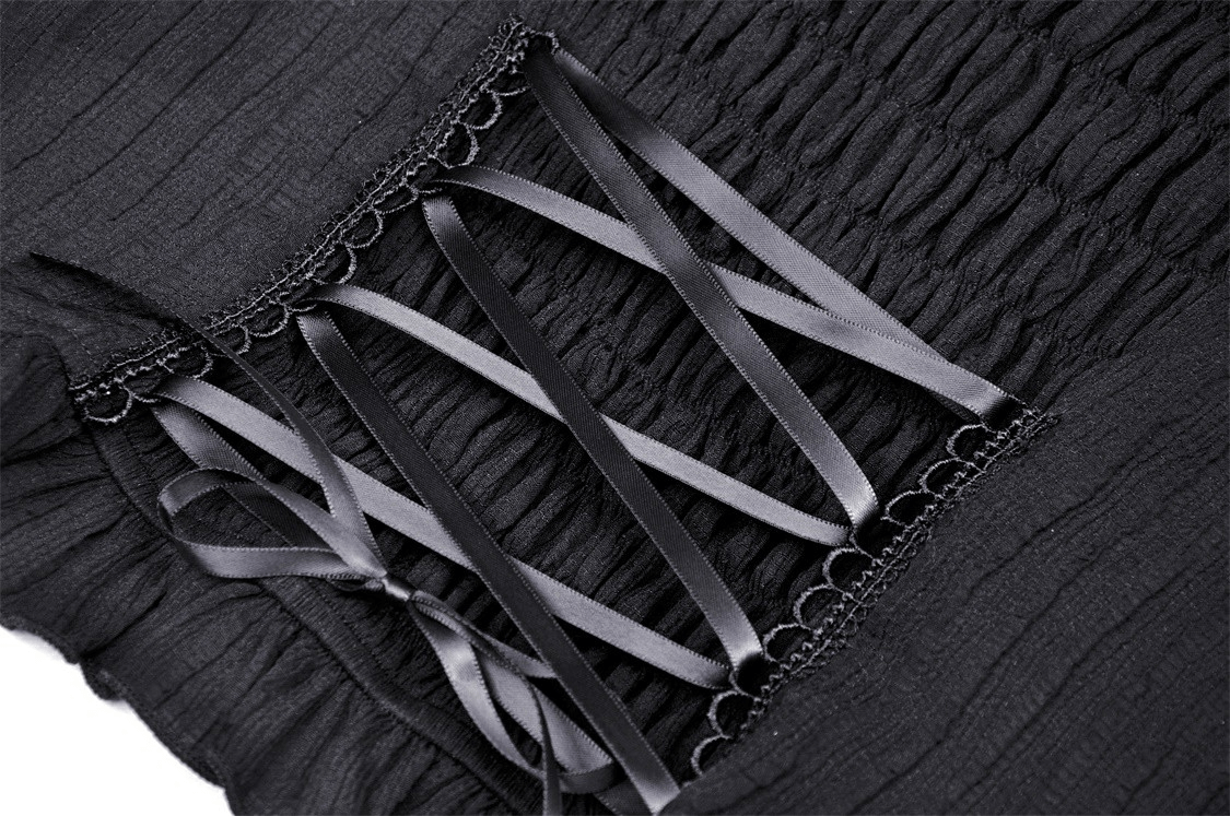 Close-up of black fabric with pink ribbon detailing showcasing gothic aesthetic.