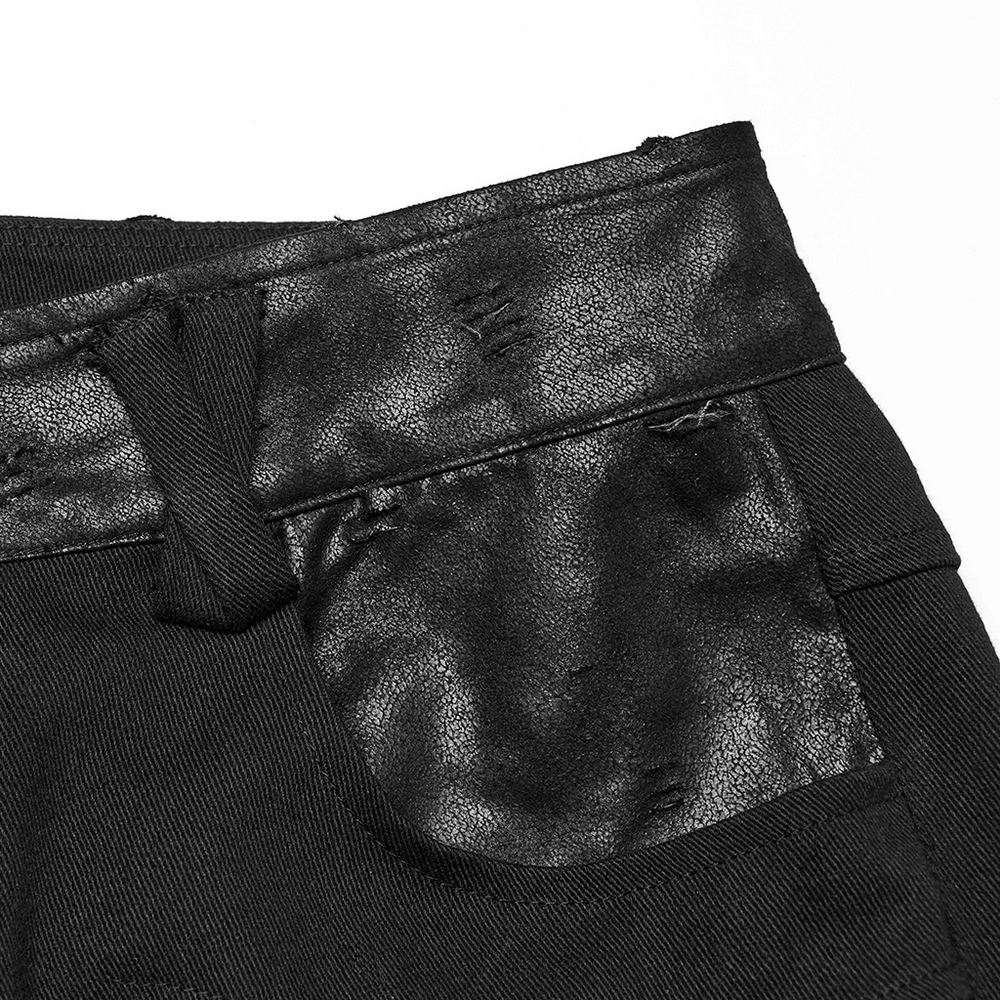 Close-up of black gothic pants featuring cracked leather detailing and stylish torn accents on the waistband.