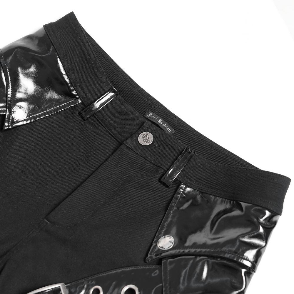 Close-up of black gothic punk pants with studded buckle, strap detail, and shiny leather-like accents.