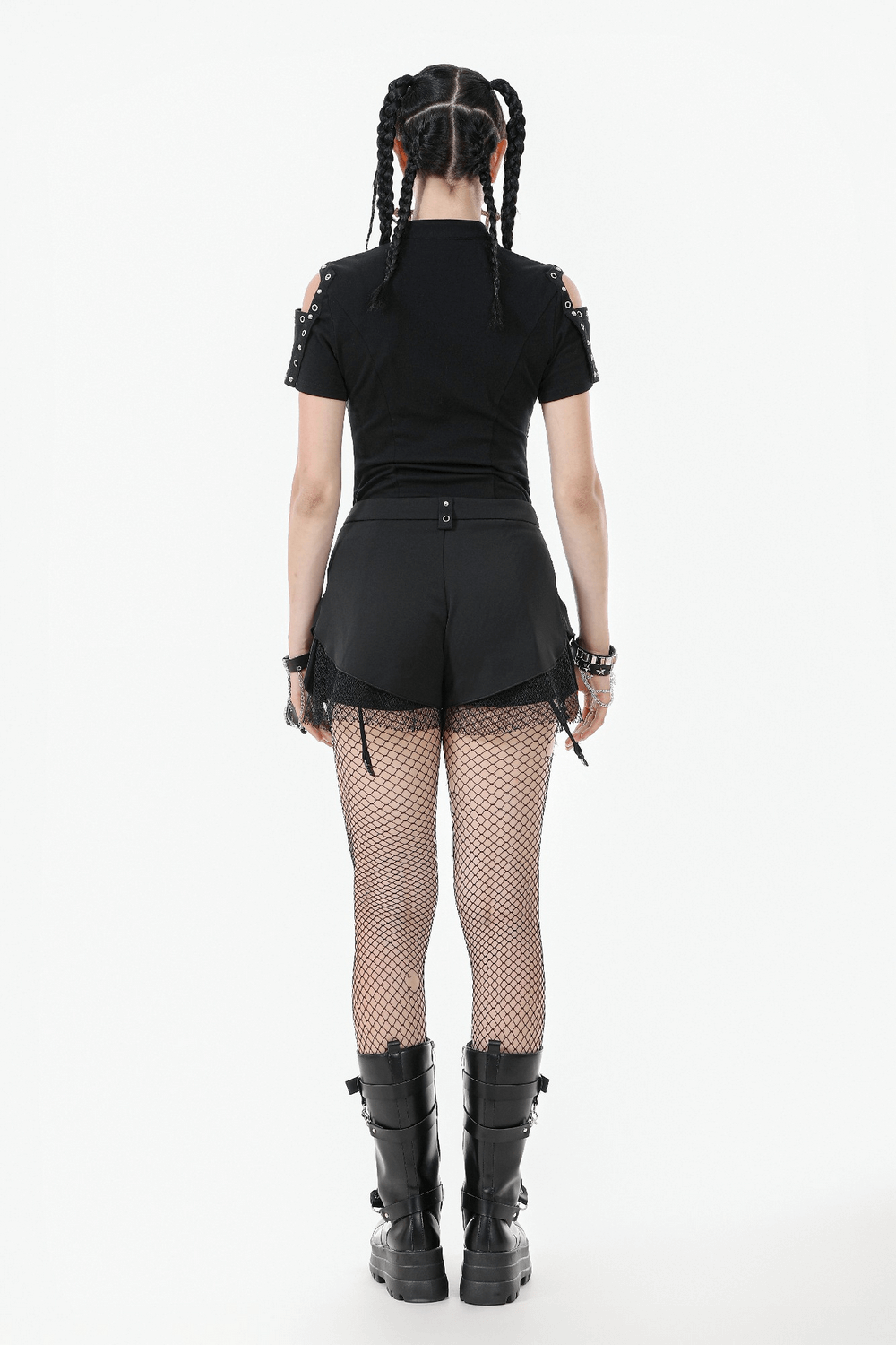 Back view of a model in black gothic shorts with straps, wearing fishnet stockings and chunky boots.