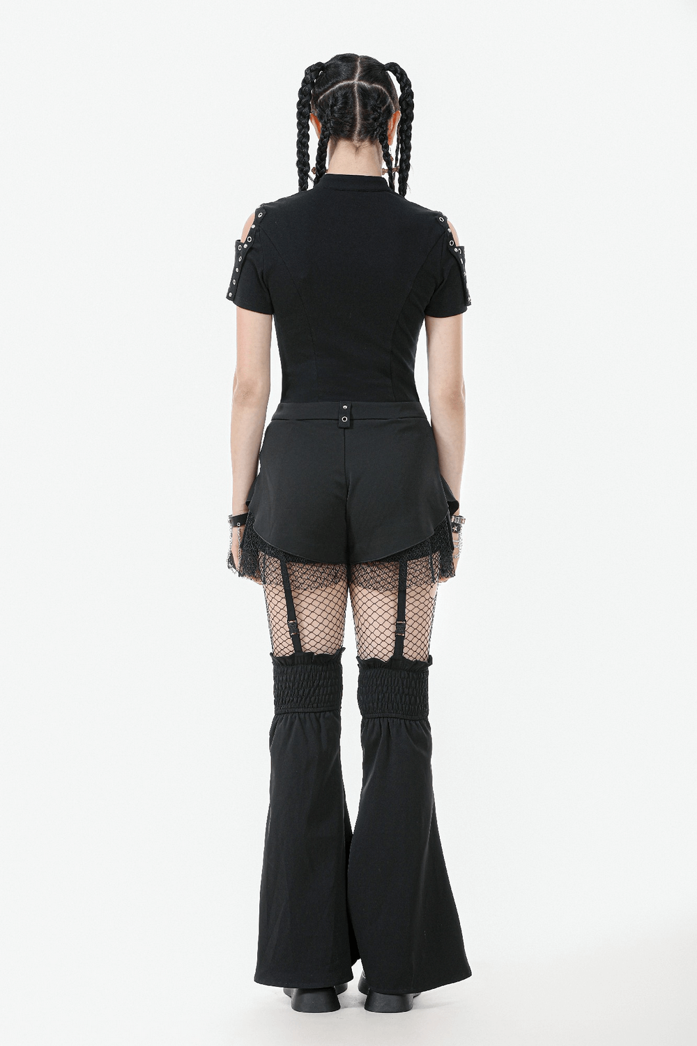 Back view of a model in black gothic shorts with straps and detachable flares, showcasing a punk-inspired look.