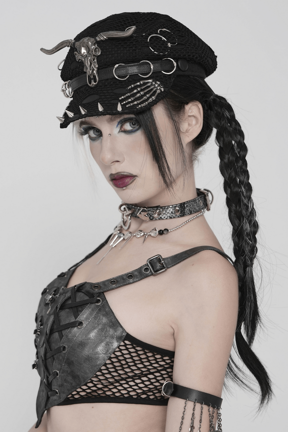 Black Gothic Skull Studded Distressed Mesh Beret worn by a model with punk attire and braids.