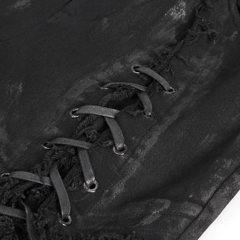 Close-up of black gothic slim-fitted pants showcasing intricate lace-up detailing and distressed fabric.