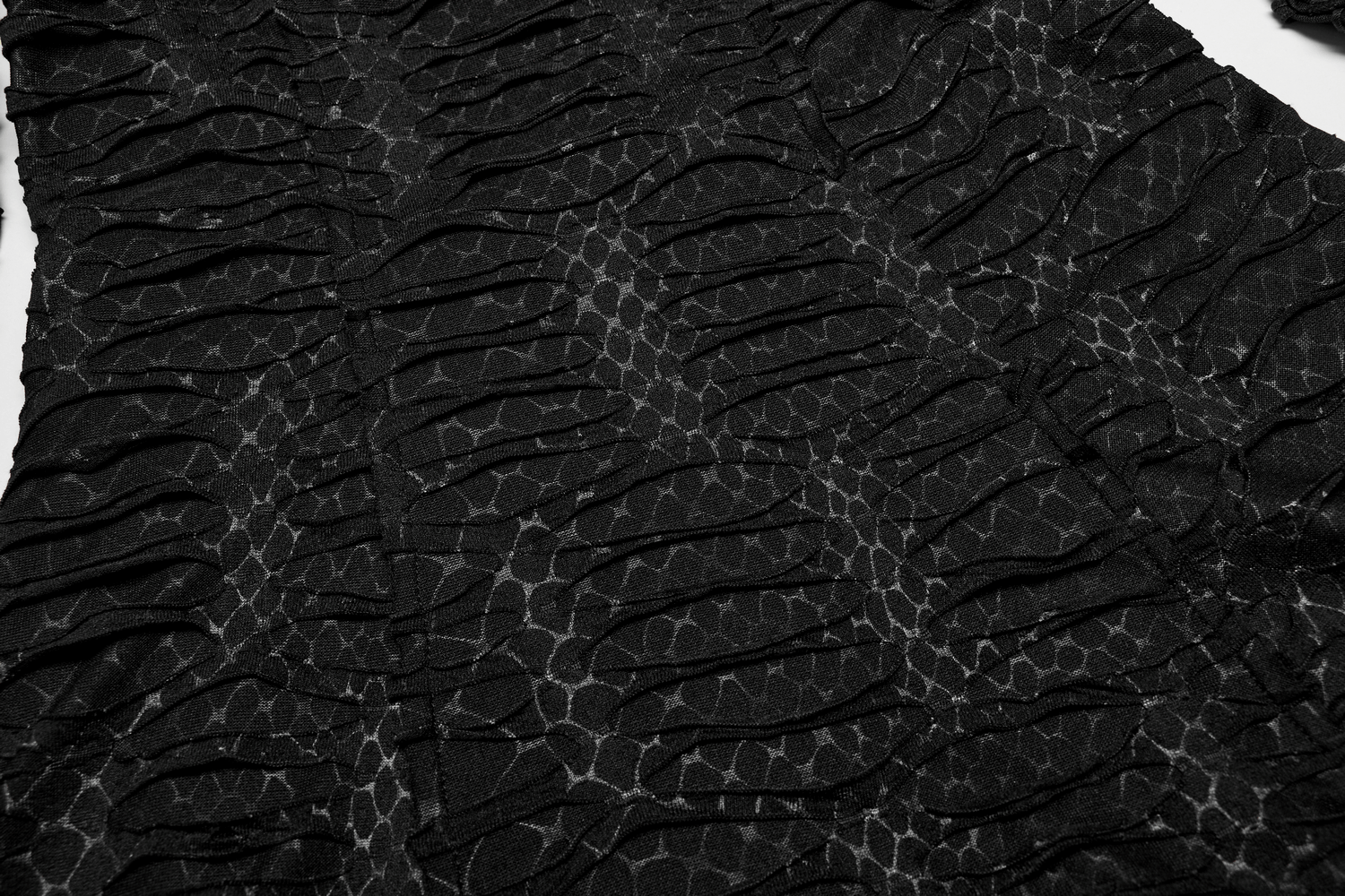 Close-up of a black gothic dress featuring layered mesh and snake print texture, showcasing intricate design details.