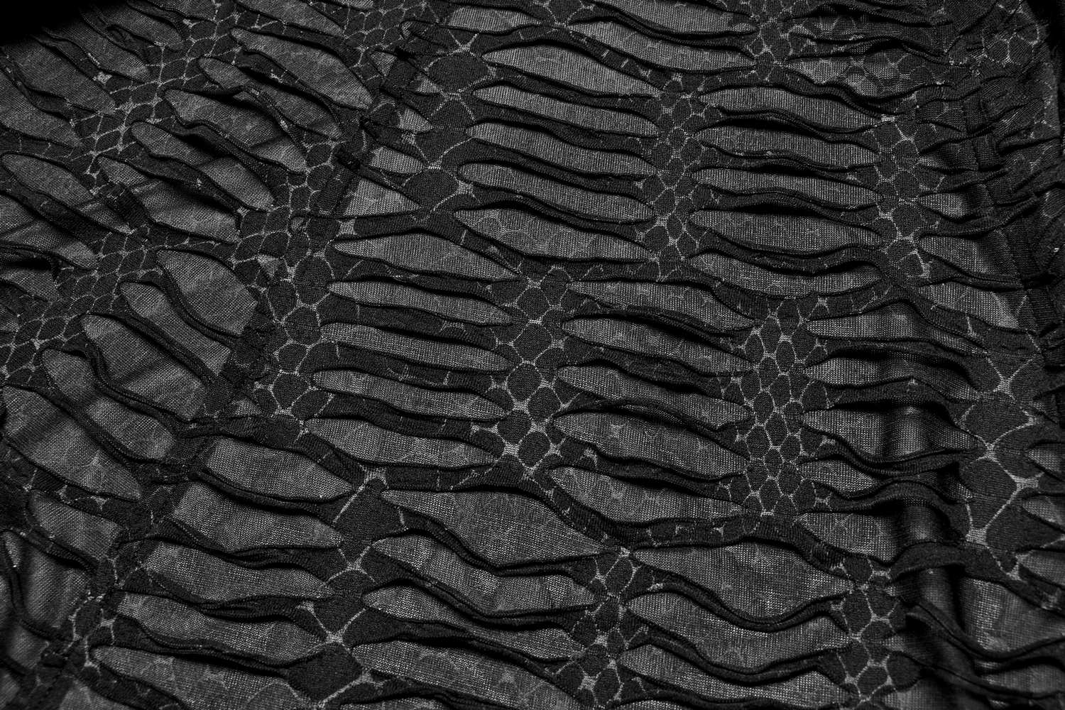 Close-up of black snakeskin fabric with textured layers, perfect for a gothic chic style.