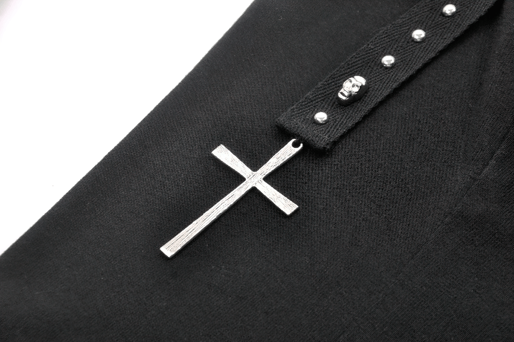 Close-up of a black gothic top featuring a studded cross and decorative silver studs.