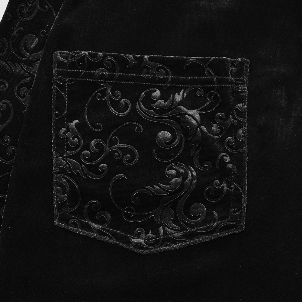 Close-up of embossed detailing on the back pocket of black gothic velvet flared pants.