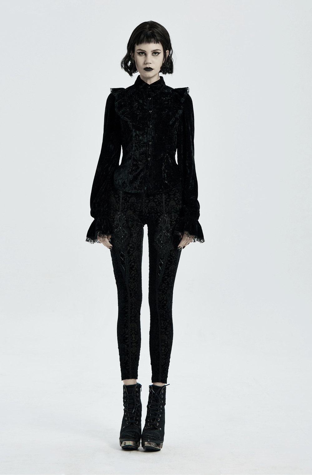 Gothic model wearing black velvet leggings with floral lace and elegant top, showcasing a chic gothic style.