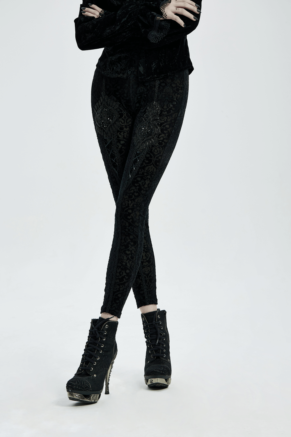 Model wearing Black Gothic Velvet Leggings with Floral Lace Detail and stylish lace-up boots.