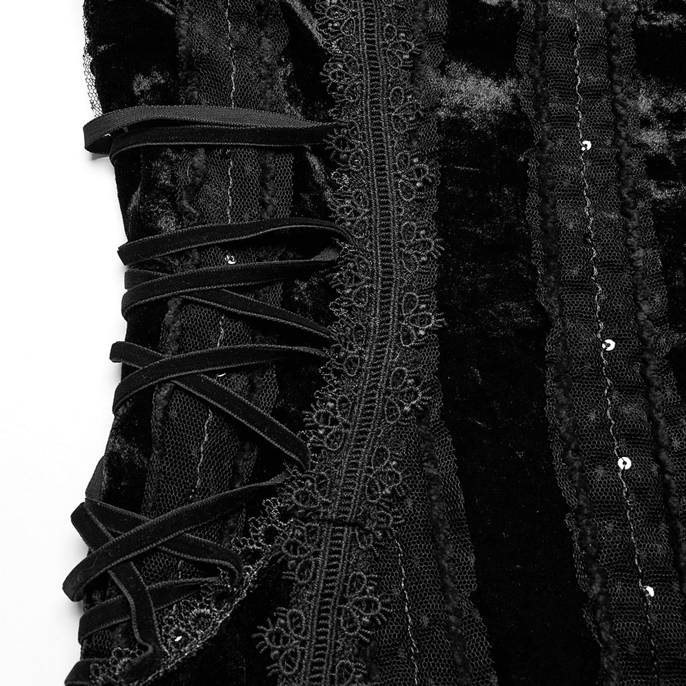 Close-up of black gothic velvet dress detailing with lace trim and adjustable straps for a stylish look.
