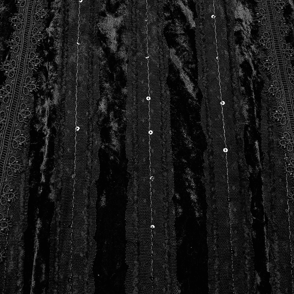 Close-up of black gothic velvet fabric with embroidered lace and sequins, showcasing elegant texture and detail.