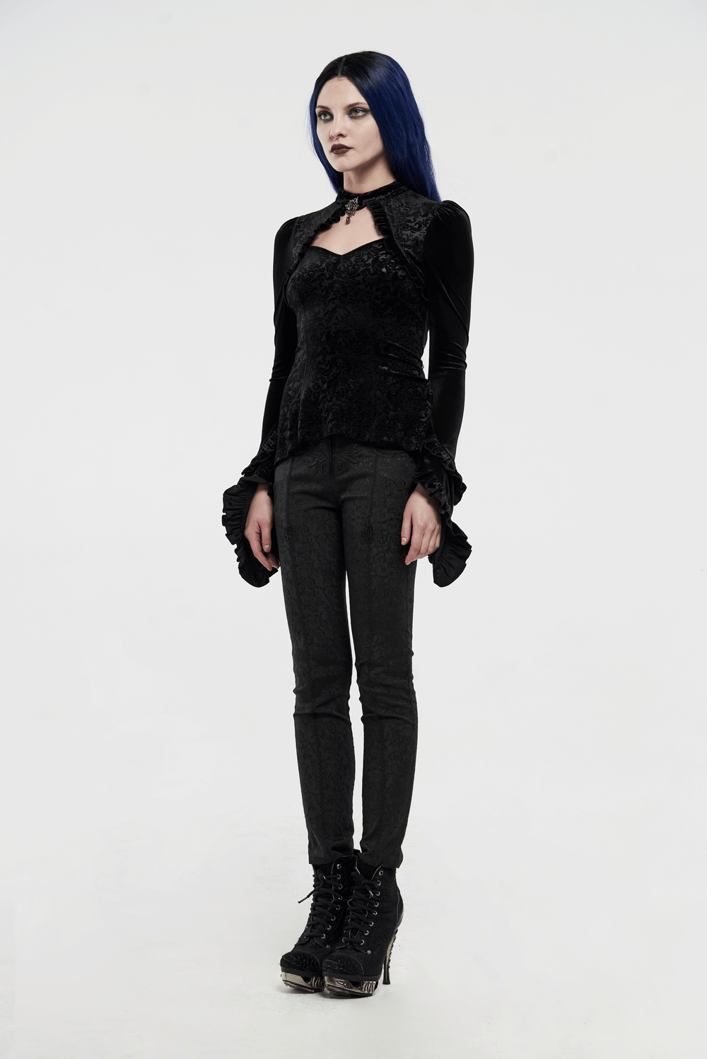 Model in a black gothic velvet lace-up top paired with dark skinny pants, showcasing a unique fashion style.