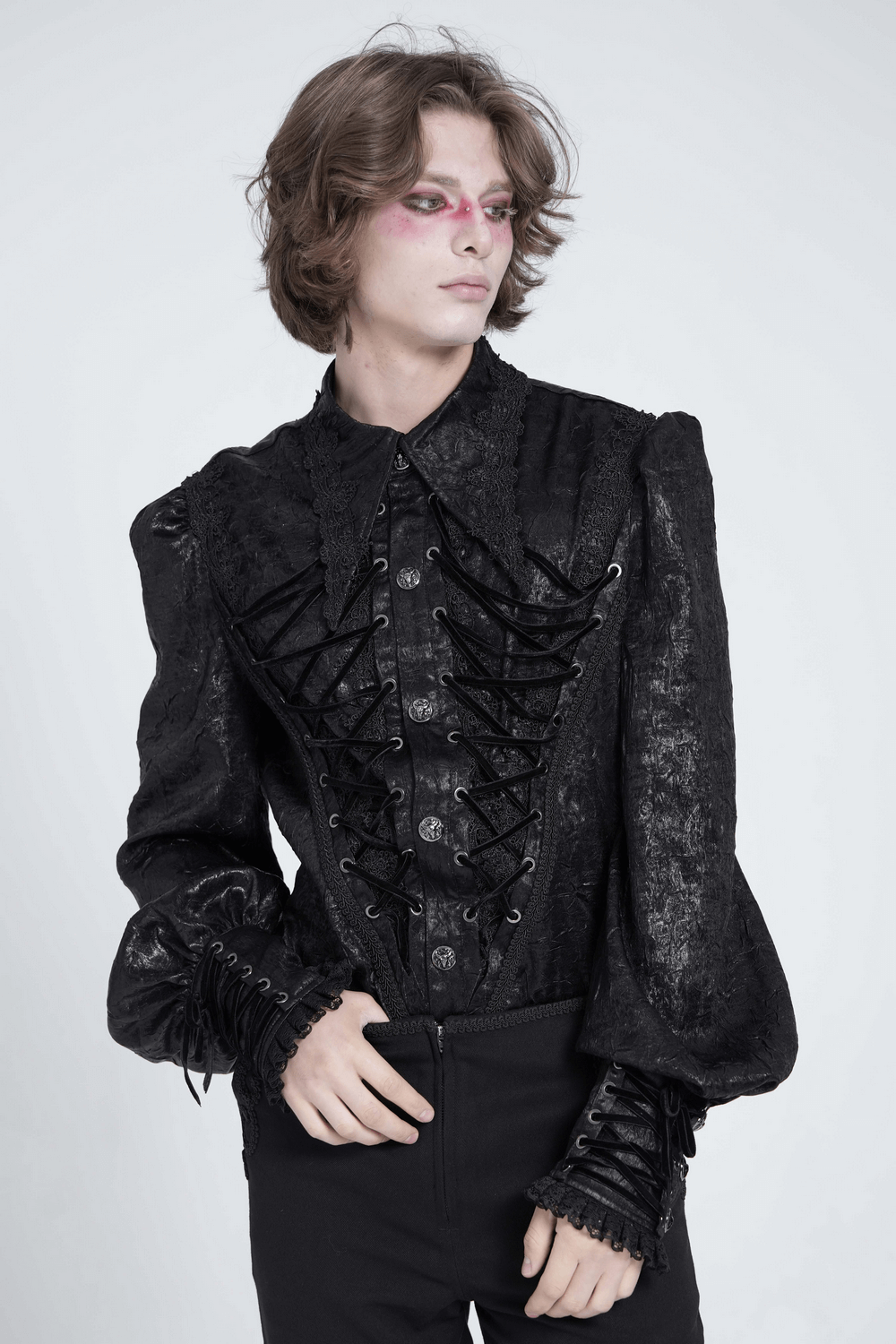 Stylish model wearing a black Gothic Victorian lace-up shirt with puff sleeves, exuding dramatic elegance.
