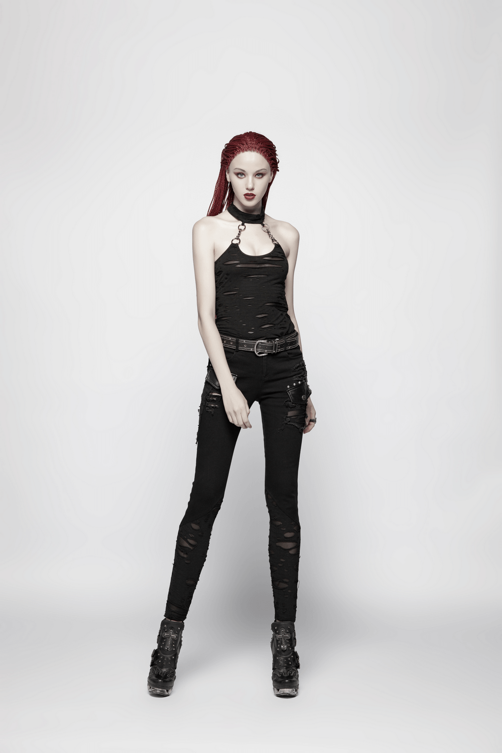 Edgy black halter crop camisole with chain detail, paired with ripped black skinny jeans for a punk rock look.