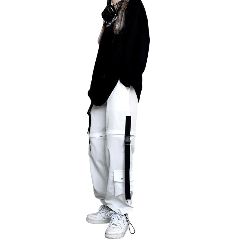 Model wearing trendy white cargo pants with black accents, styled with a black top and sneakers, perfect for street fashion.