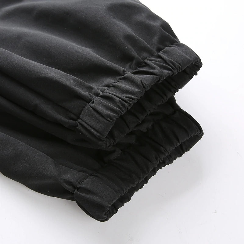 Close-up of black high waist cargo pant cuffs, showcasing elastic detailing for a stylish streetwear look.