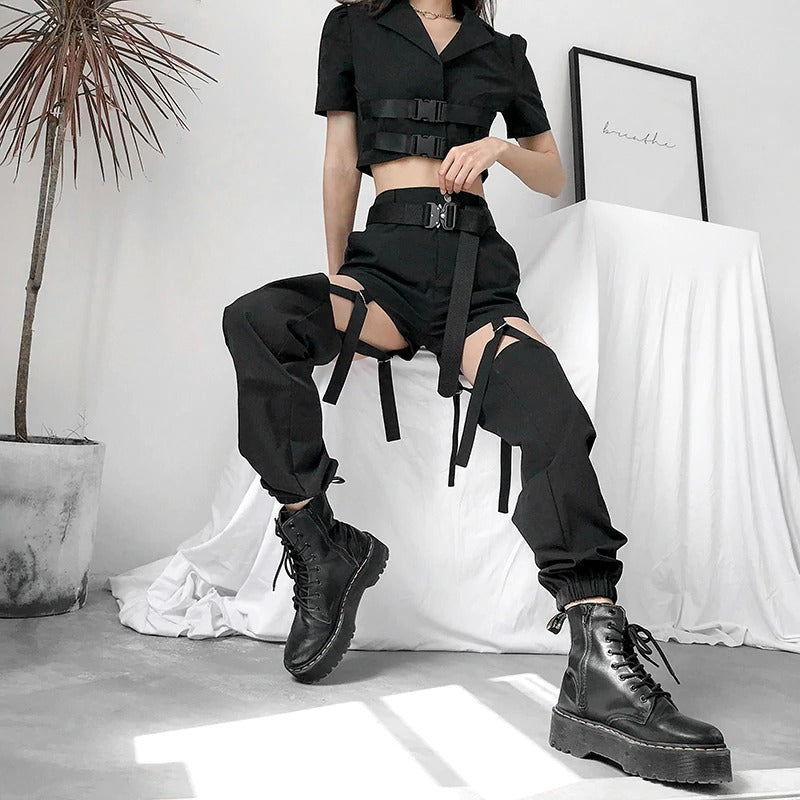 Black high waist cargo pants with buckles and hollow out design for street style and dance performances.